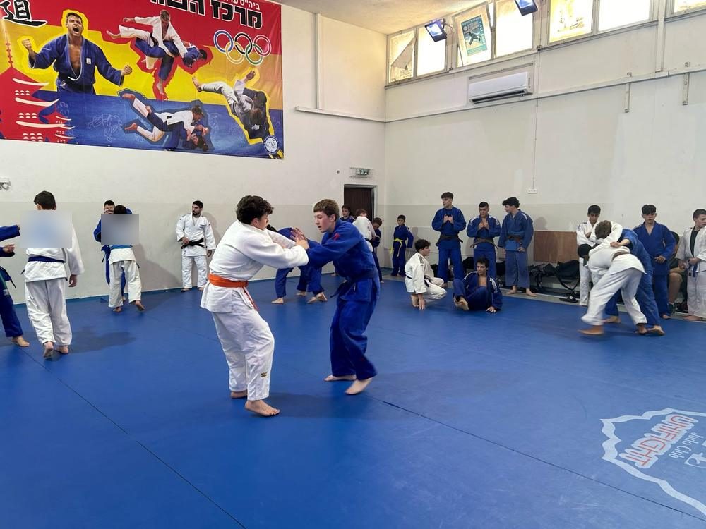 זוגות מתאמנים ברנדורי על המזרן הכחול במחנה האימונים